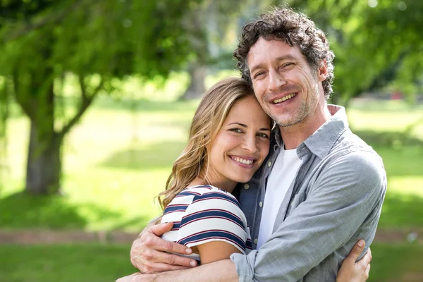 Sonriente pareja abrazándose en el parque — Foto de Stock