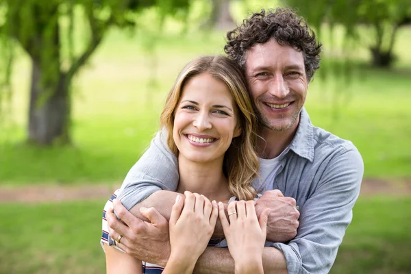 Lächelndes Paar umarmt sich im Park — Stockfoto