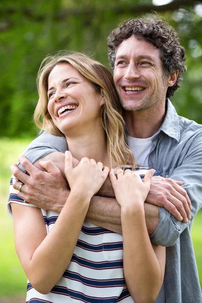 Sonriente pareja abrazándose en el parque — Foto de Stock