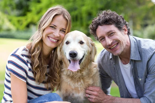 Lachende echtpaar met hond in het park — Stockfoto