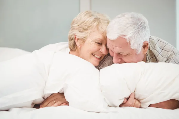 Pareja mayor juguetona descansando en la cama — Foto de Stock