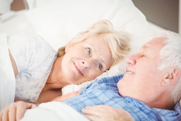 Mulher olhando para o marido na cama — Fotografia de Stock