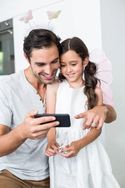 Отец с помощью смартфона с дочерью — стоковое фото