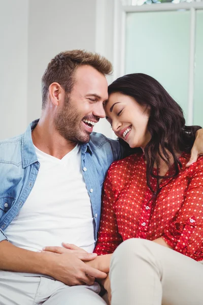 Pareja sentada en sofá en casa — Foto de Stock