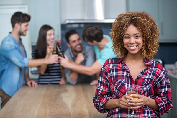 Femme tenant du vin tandis que des amis en arrière-plan — Photo