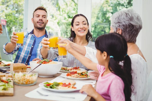 Glückliche Familie prostet Saft zu — Stockfoto