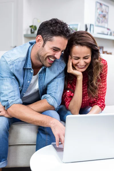 Pareja alegre usando el ordenador portátil — Foto de Stock