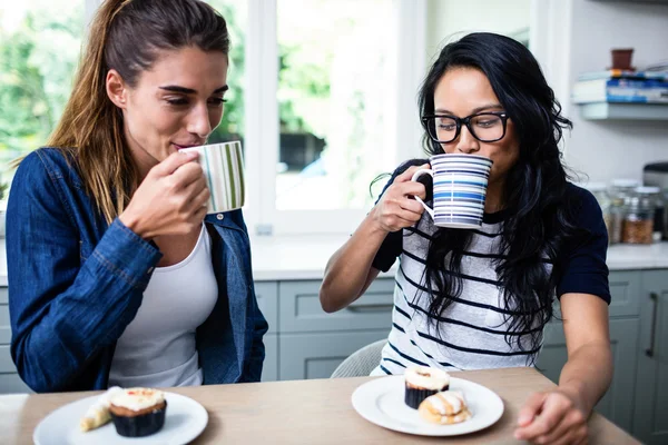 Freundinnen trinken Kaffee am Tisch — Stockfoto