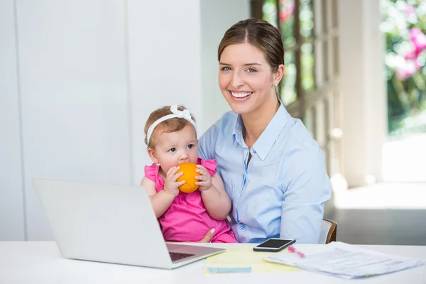 Mulher sentada com bebê à mesa — Fotografia de Stock