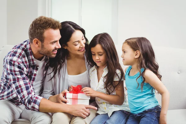 Padres con hijas sosteniendo regalo — Foto de Stock