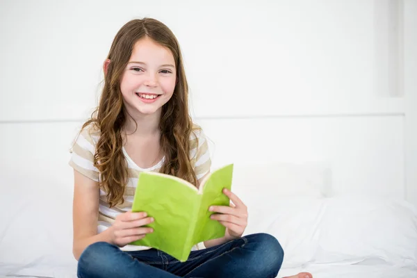 Meisje leesboek op bed — Stockfoto