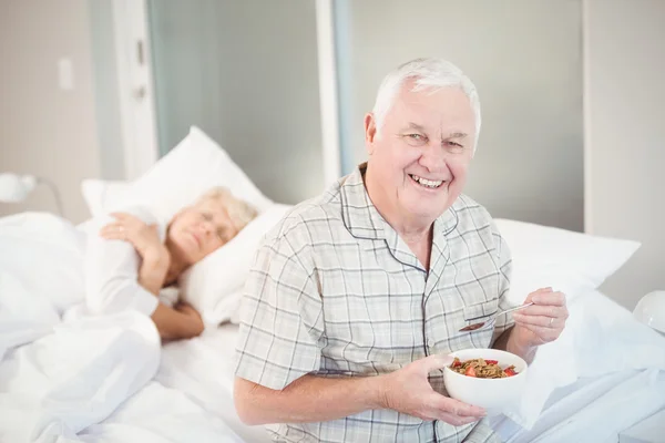 Feliz hombre mayor teniendo ensalada por la esposa dormida —  Fotos de Stock