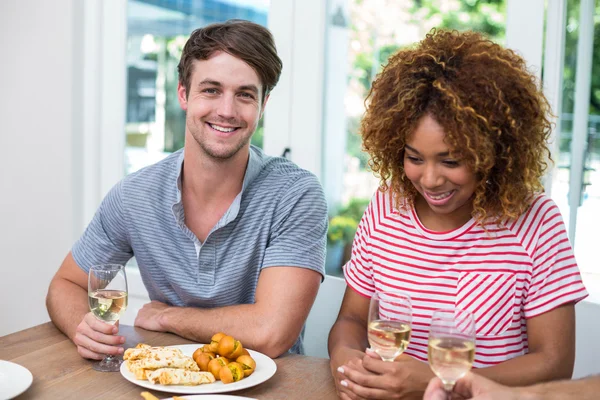 Vrienden met wijn en spijs op tafel — Stockfoto