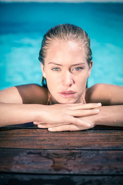 Bella donna appoggiata a bordo piscina — Foto Stock