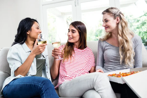 Vriendinnen met pizza drinken van wijn — Stockfoto