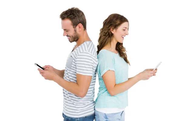 Couple text messaging on mobile phones — Stock Photo, Image