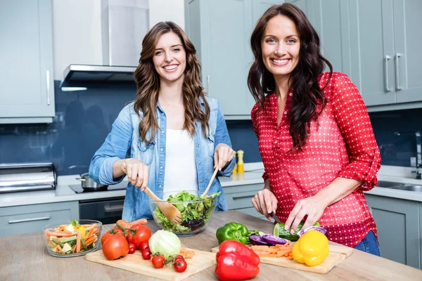 Freundinnen bereiten Gemüsesalat zu — Stockfoto