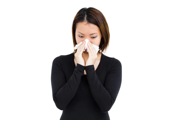 Sick woman blowing nose with paper — Stock Photo, Image