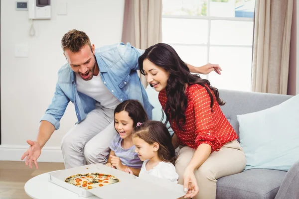 Rodzina czterech patrząc na pizzę — Zdjęcie stockowe