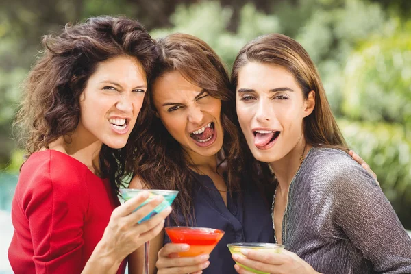 Amigos haciendo cara mientras beben cócteles —  Fotos de Stock