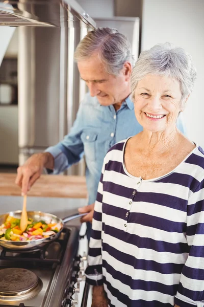 음식을 요리 하는 남편과 함께 서 있는 여자 — 스톡 사진