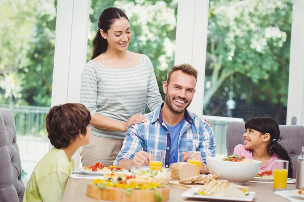 Familj med mamma står vid matbord — Stockfoto