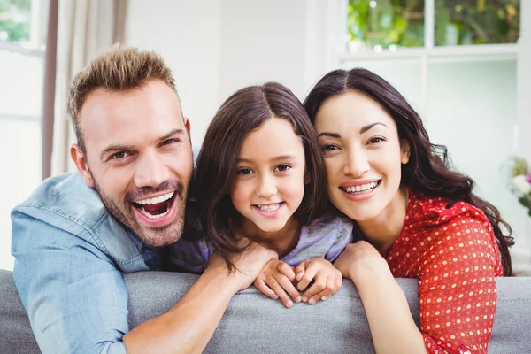 Padres con hija en el sofá en casa —  Fotos de Stock