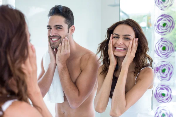 Paar reiniging gezicht in badkamer — Stockfoto