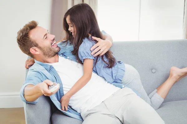 Figlia abbracciare padre seduto sul divano — Foto Stock