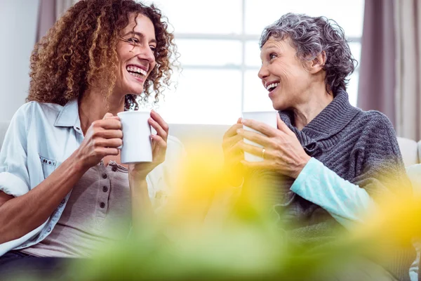 Mor och dotter håller kaffe muggar — Stockfoto