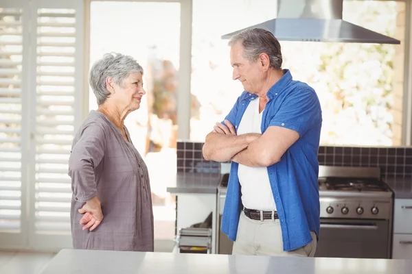 Seitenansicht eines älteren Ehepaares, das sich in der Küche unterhält — Stockfoto