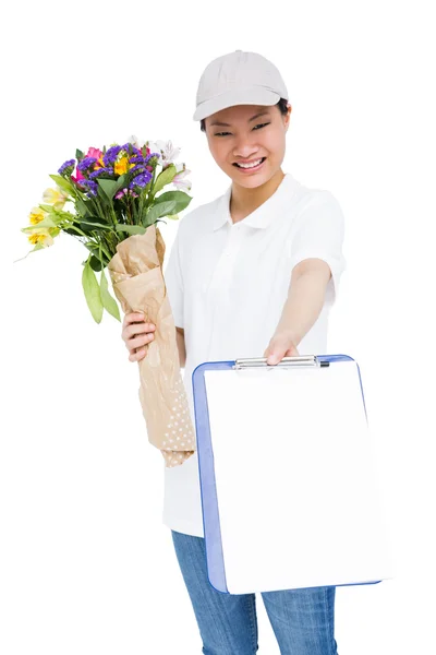Delivery woman with bouquet and clipboard — Stock Photo, Image