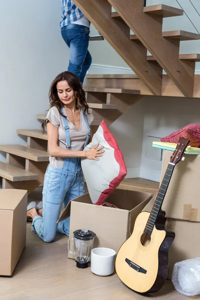 Frau packt Kissen aus Pappschachtel — Stockfoto