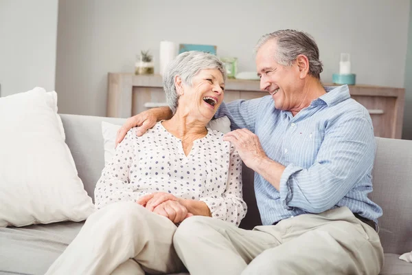 Senior couple laughing on sofa — Stock Photo, Image