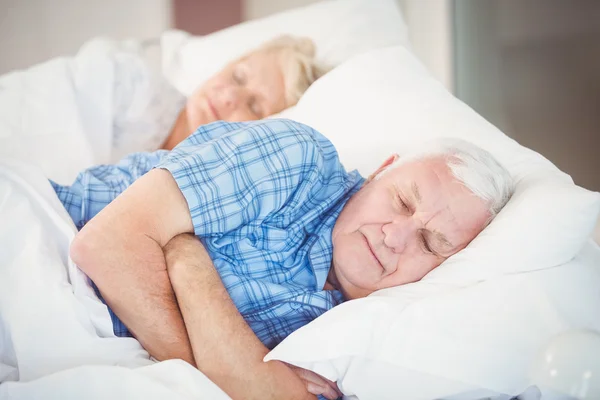 Seniorenpaar schläft auf Bett — Stockfoto