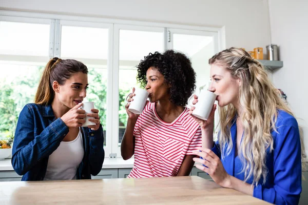 Freunde trinken Kaffee und sitzen am Tisch — Stockfoto