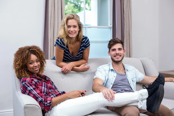 Amigos felizes relaxando no sofá — Fotografia de Stock