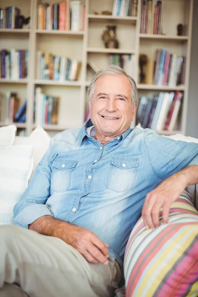 Portrait of happy senior man sitting on sofa — Stock Photo, Image