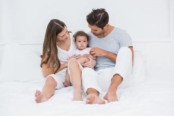 Родители с ребенком сидят на кровати — стоковое фото