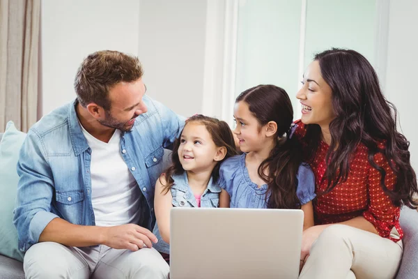 Rodzina uśmiechając się i korzysta z laptopa — Zdjęcie stockowe