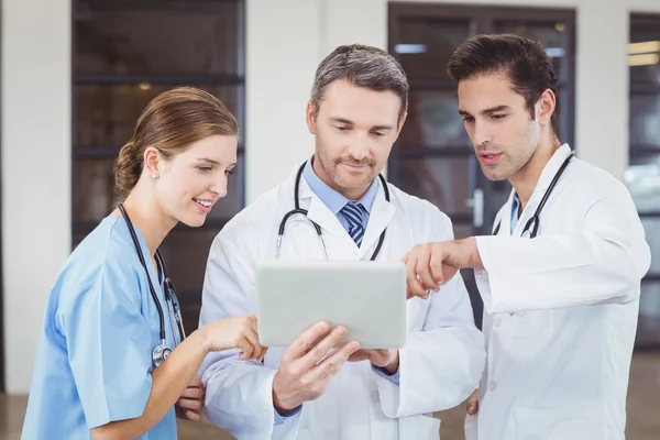 Médicos discutindo enquanto seguram tablet digital — Fotografia de Stock