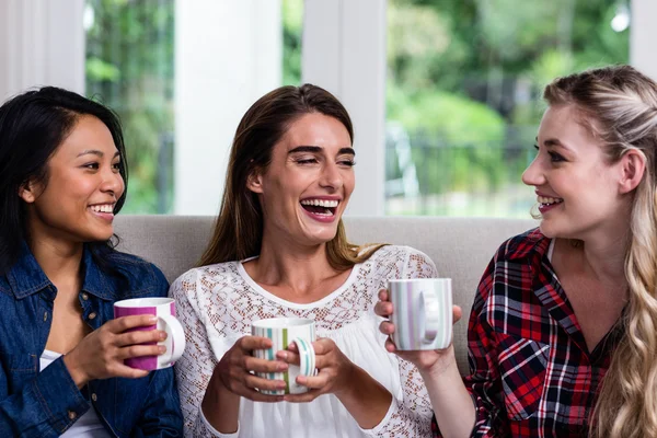 Vrouwelijke vrienden met koffie cups thuis — Stockfoto