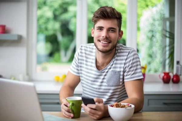 Homem usando telefone enquanto toma café — Fotografia de Stock