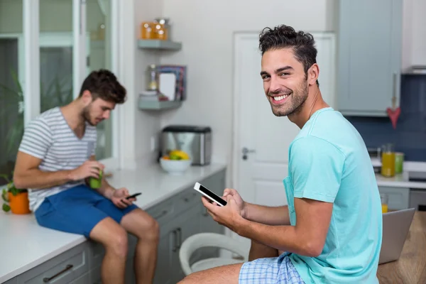 Homme souriant utilisant le téléphone avec un ami — Photo