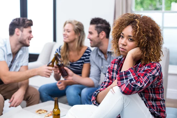 Doordachte vrouw met vrienden op achtergrond — Stockfoto