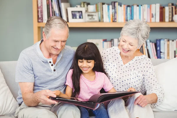 Nonni che mostrano album a nipote a casa — Foto Stock