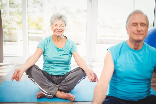 Mulher sênior sorridente com marido meditando — Fotografia de Stock