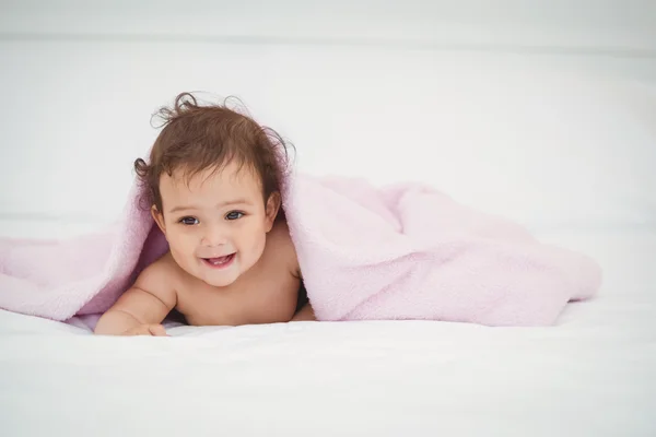 Cute smiling baby lying under blanket — Stock Photo, Image