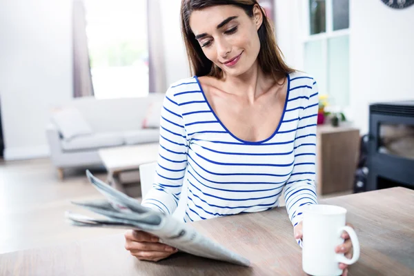 Frau mit Zeitung und Becher — Stockfoto