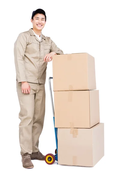 Deliveryman standing beside luggage trolley — Stock Photo, Image